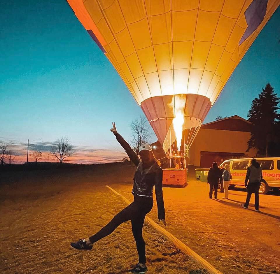 Balloon crew preparing the basket while dawn light hits the fields